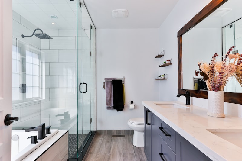 Freshly cleaned commercial bathroom, glass shower and stone counter