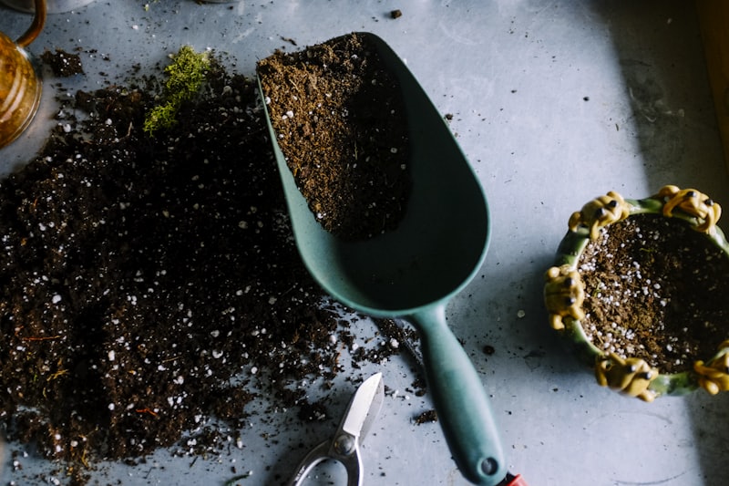 Landscaper scooping soil with a trowel over a garden bed