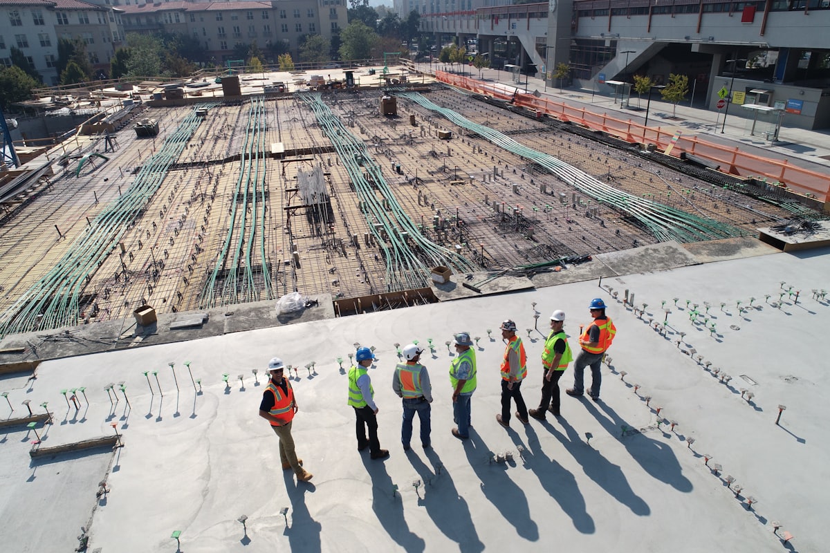 Framing crew in hard hats walking a concrete slab at a job site